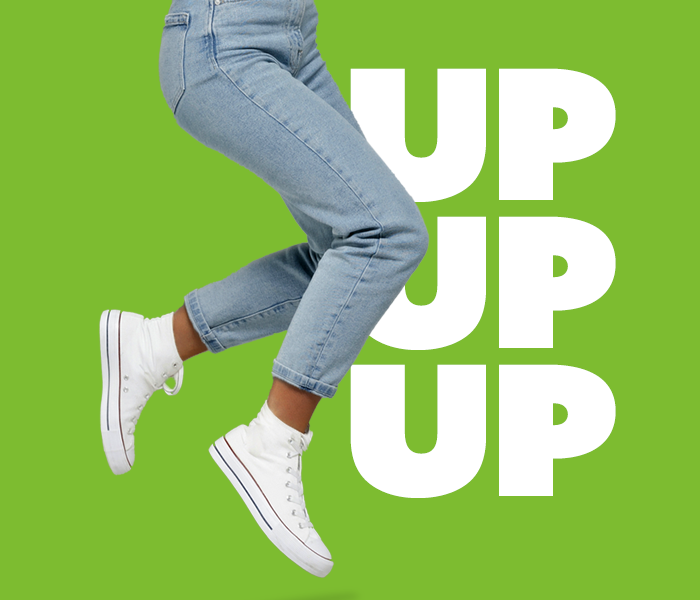 A person shown jumping in front of a green background- only their jeans and white hightops are visible. Text to the right reads