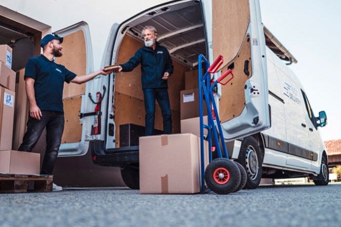 Two men unloading boxes from delivery truck
